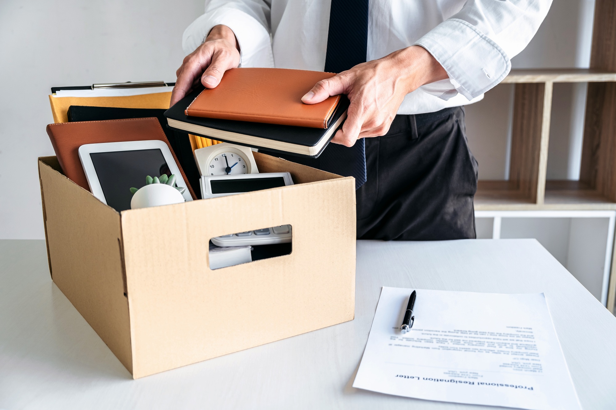 Images of businessman carrying packing up all his personal belon