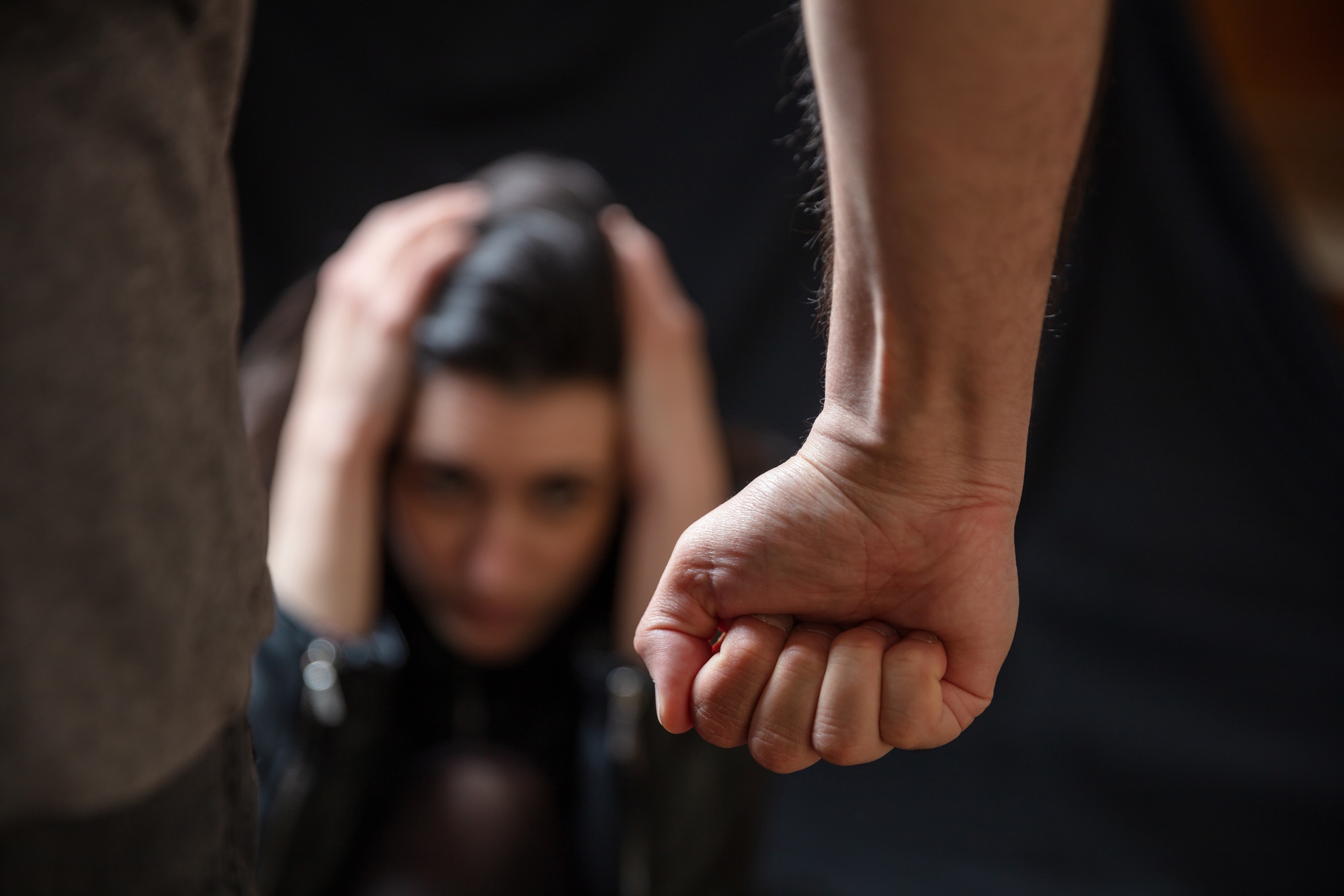 Woman abuse, Young woman scared, male clenched fist close up. Domestic violence